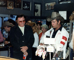 Webb Pierce listening to his long-time pal, Max Powell, playing a song at the Willie Nelson Geneal Store in Nashville, TN.